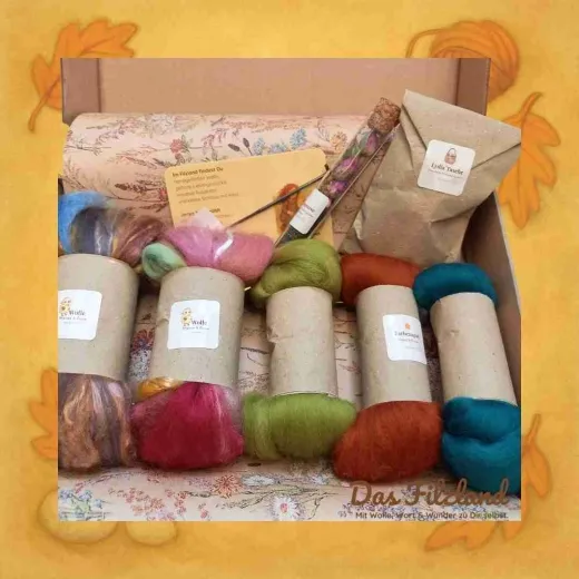 Die geöffnete Frühlings-Materialbox mit ausgewählten Wollfarben, Anleitung und kleinen Naturdetails. Artikelbild 2