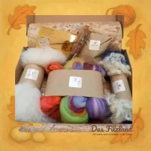 Die geöffnete Sommer-Materialbox mit leuchtenden Wollfarben, Anleitung und sommerlichen Naturdetails.