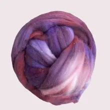 Ein Kammzug wie ein letzter Sonnenstrahl – in warmen Blau-, Lila- und Brauntönen, handgefärbt auf weicher Bio-Merinowolle.