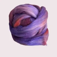 Ein Kammzug wie ein letzter Sonnenstrahl – in warmen Blau-, Lila- und Brauntönen, handgefärbt auf weicher Bio-Merinowolle.