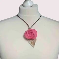 Diese elegante Filzkette verbindet eine lebhafte pinke Filzrose mit einem sanften Keramikblatt in Beigetönen, alles an einem stilvollen braunen Lederband befestigt. Ideal für jede Gelegenheit, bringt sie Farbe und Individualität in dein Outfit. Jedes Det