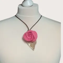 Diese elegante Filzkette verbindet eine lebhafte pinke Filzrose mit einem sanften Keramikblatt in Beigetönen, alles an einem stilvollen braunen Lederband befestigt. Ideal für jede Gelegenheit, bringt sie Farbe und Individualität in dein Outfit. Jedes Deta